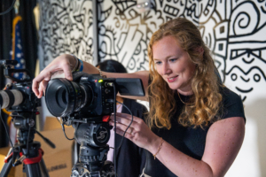 woman checking viewfinder in camera